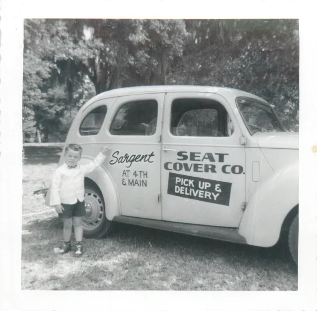 El joven Mike Todd con el auto de entregas de Sargent Seat Cover Co.